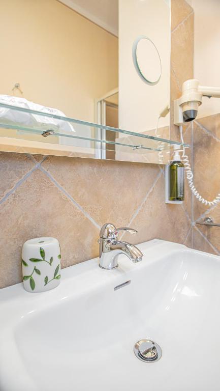 a bathroom counter with a sink and a mirror at Hotel Lu Pitrali in San Teodoro