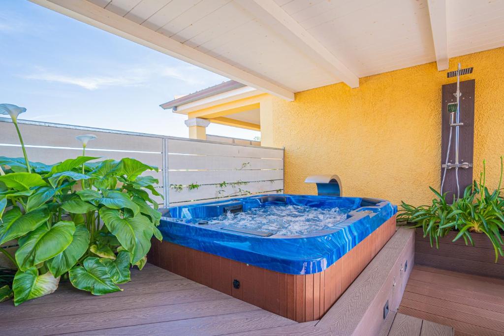 a hot tub on a balcony with plants at Hotel Lu Pitrali in San Teodoro