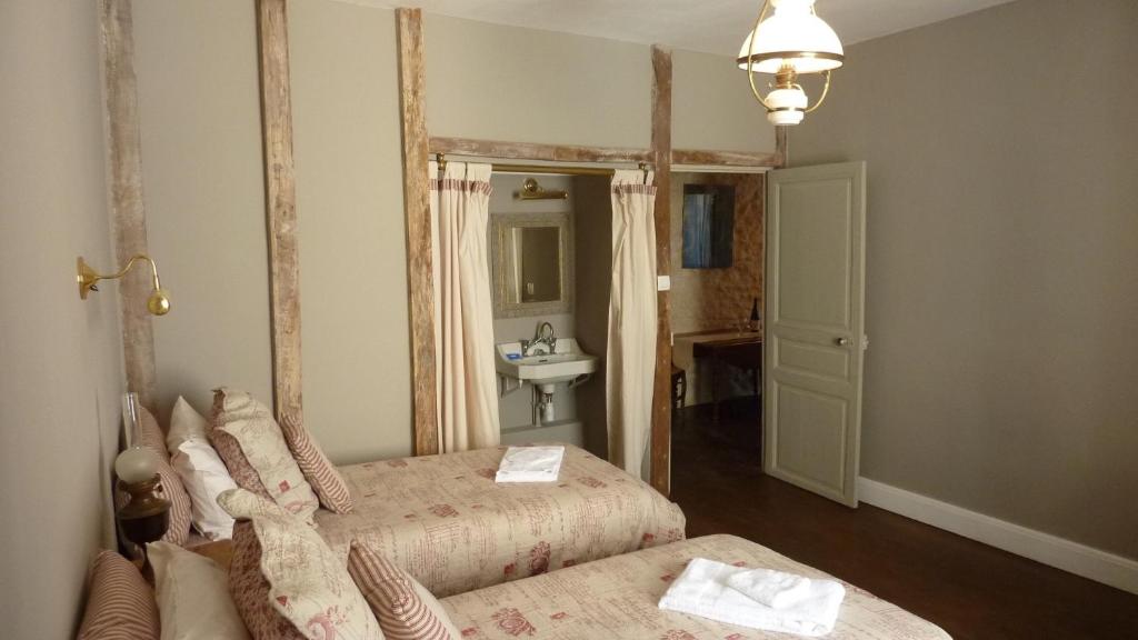 - une chambre avec 2 lits et une salle de bains avec lavabo dans l'établissement Le Logis Alexandra BnB, à La Trimouille