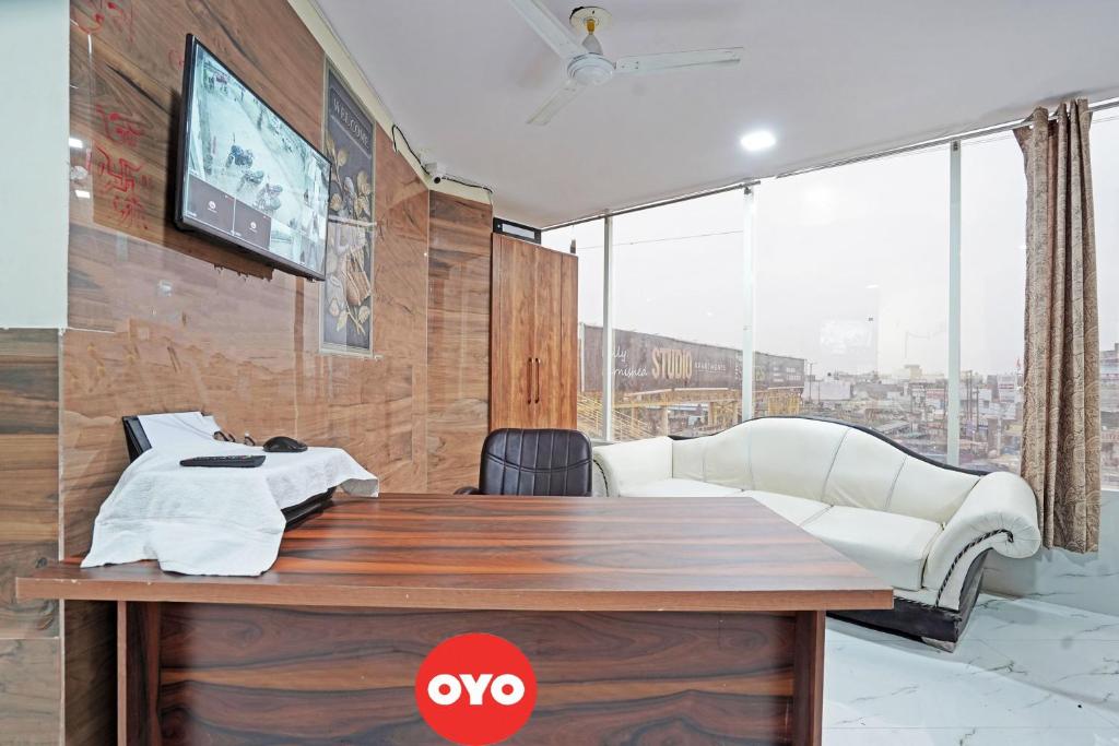 OYO Flagship Hotel Jojo In في غازي آباد: غرفة معيشة مع طاولة وتلفزيون