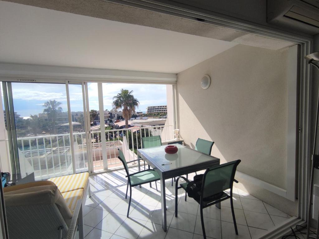 un salon avec une table et des chaises sur un balcon dans l'établissement Appartement 204, Natura Beach au village naturiste, au Cap d'Agde