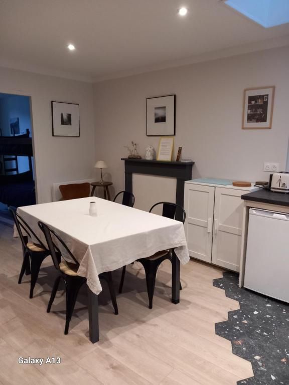 uma cozinha com uma mesa branca e cadeiras num quarto em L'auseth em Oloron-Sainte-Marie