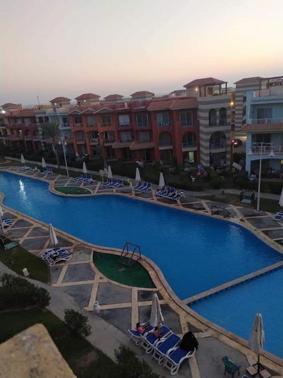 a large swimming pool with chairs and umbrellas at Porto matrouh in Marsa Matruh