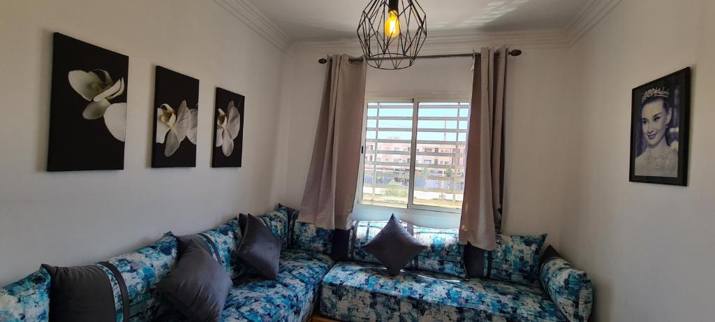 uma sala de estar com um sofá e uma janela em Les portes de Gueliz - apartment 6 people em Marrakech