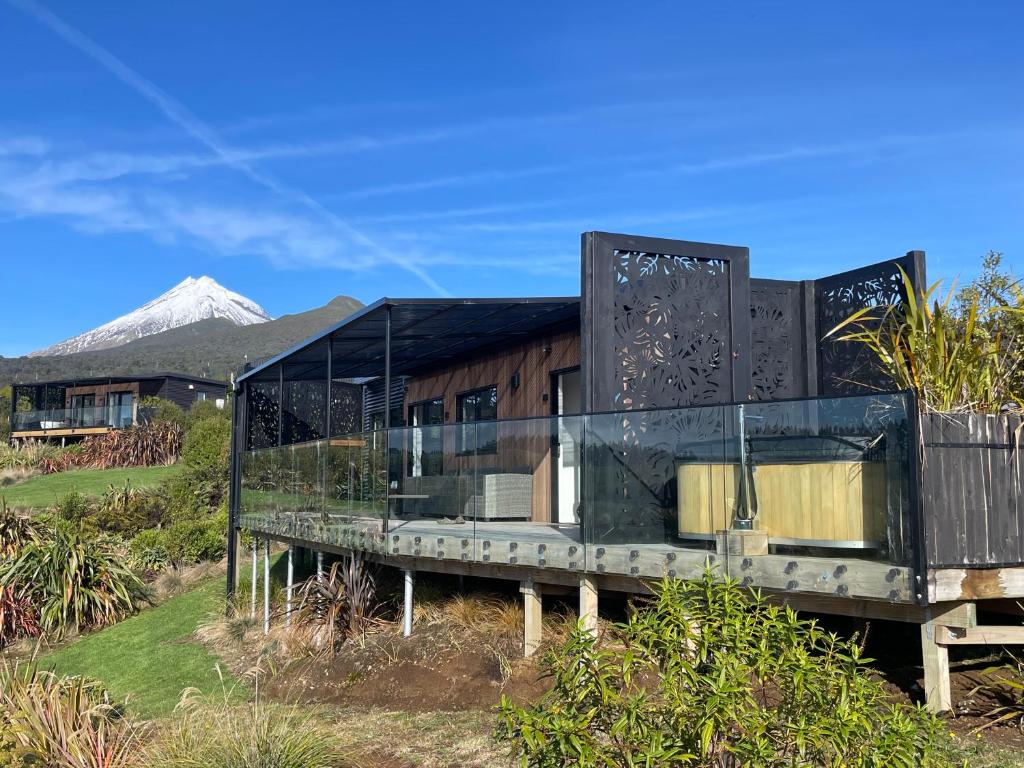 a glass house with a mountain in the background at Mangorei Heights - New Plymouth in New Plymouth
