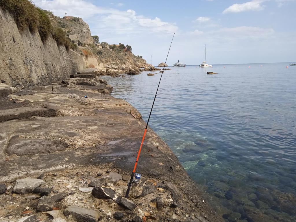 a fishing rod on the side of the water at Tiny house Taormina mare with sofa bed - mini stanza Taormina mare con divano letto in Taormina