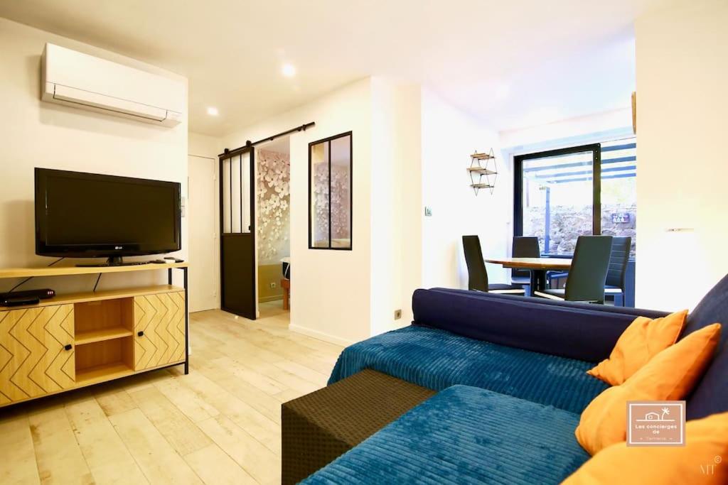 un salon avec un canapé bleu et une télévision dans l'établissement le Fan-ny climatisé et accès plage, à La Seyne-sur-Mer