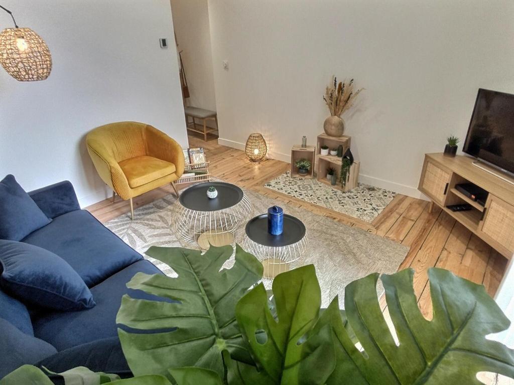 un salon avec un canapé bleu et une télévision dans l'établissement Le Lautrec - Vue Cathédrale - Centre-Ville, à Albi