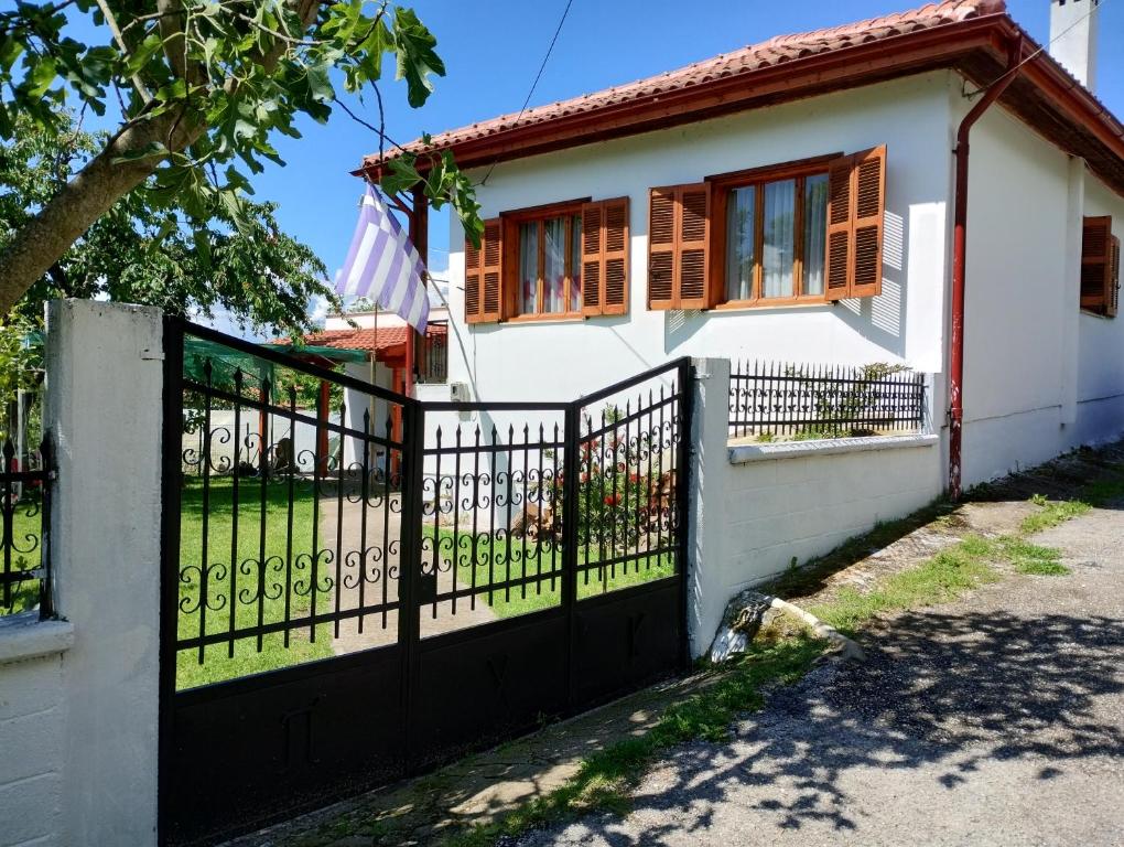 een wit huis met een zwart hek bij Τα πλατάνια 