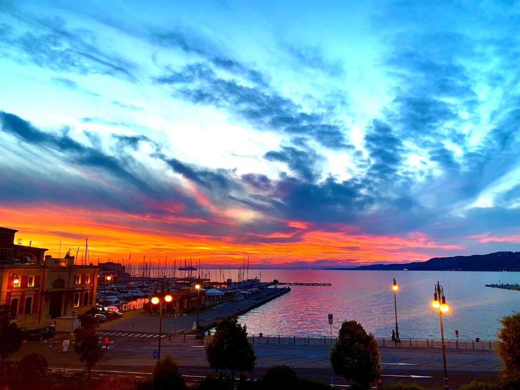 a sunset over a body of water with a pier at Five Flowers Guest House - self check-in in Trieste