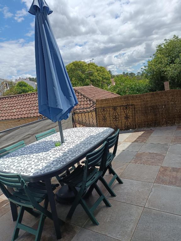 un parapluie bleu posé sur une table sur une terrasse dans l'établissement T3 terrasse calme Nîmes proche centre, à Nîmes