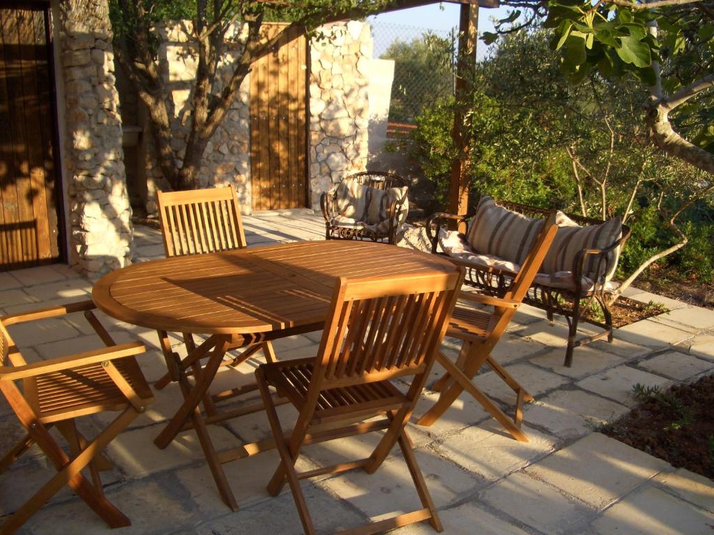 un tavolo in legno e sedie posti su un patio di Salento d a mare a Torre Pali