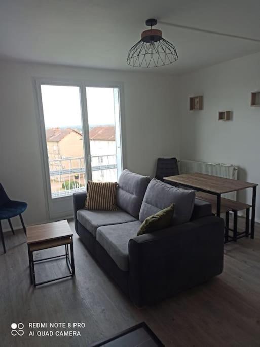 un salon avec un canapé et une table dans l'établissement Appartement 2 chambres, 3 couchages, à Paray-le-Monial