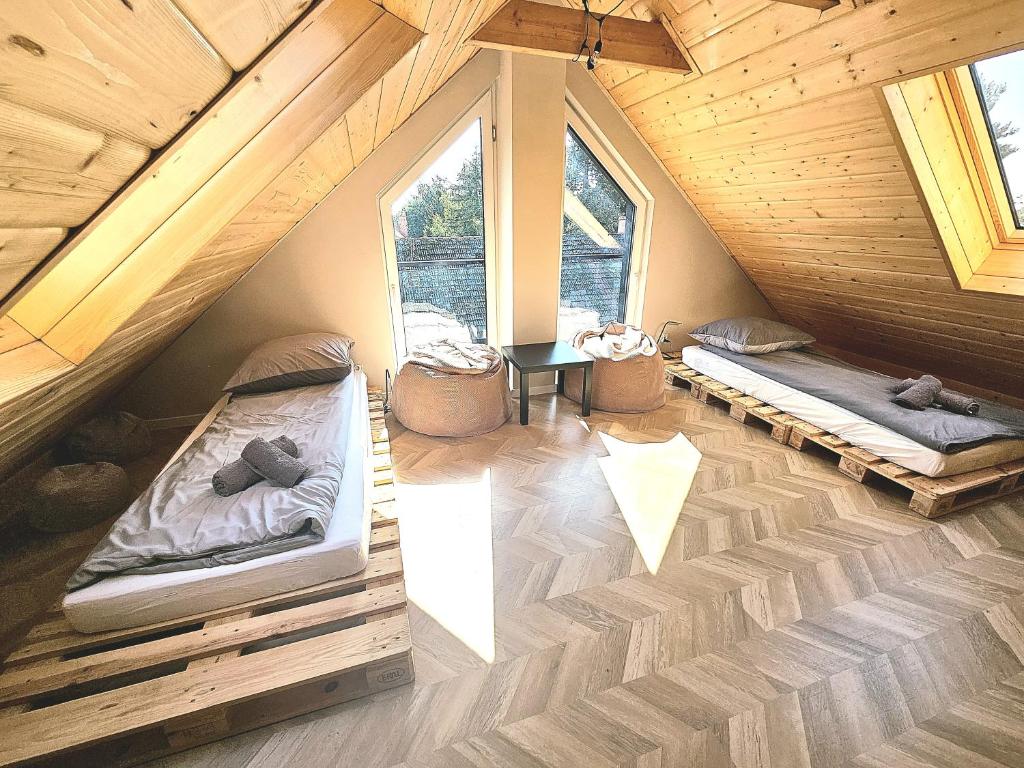 Habitación en el ático con 2 camas y mesa en M&K Apartamenty Przystań Świbno, en Gdansk