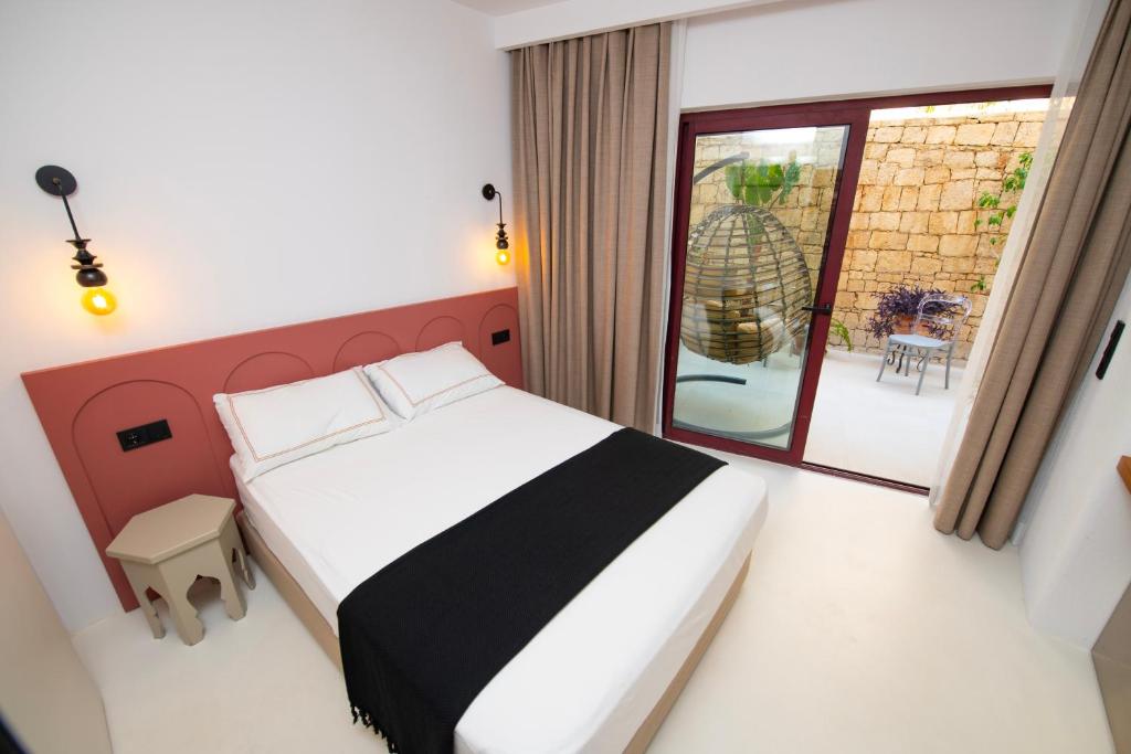 a bedroom with a bed and a large window at Hotel Begonvil in Kas