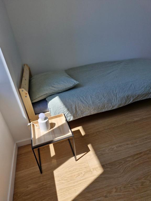- une petite chambre avec un lit et une table dans l&#39;établissement Grand appart renové centre ville, à Perros-Guirec
