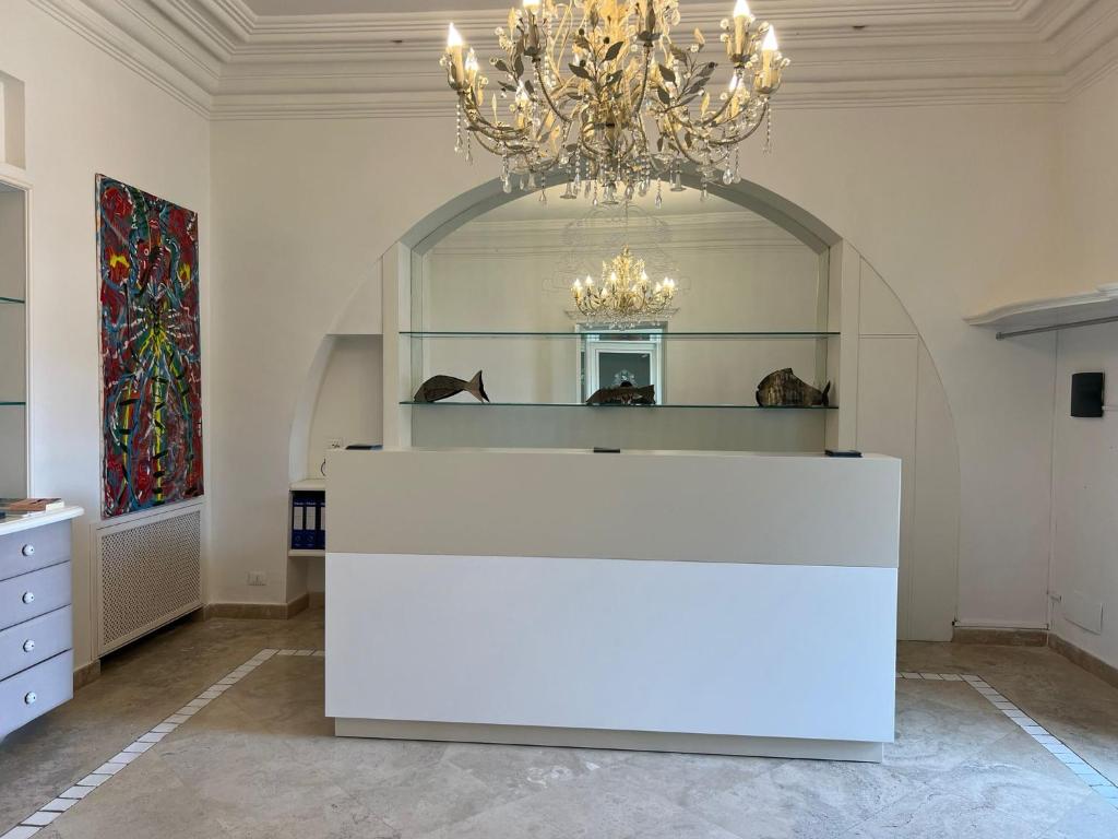 a large room with a chandelier and a white counter at Relais Corte Degli Aragonesi in Ischia