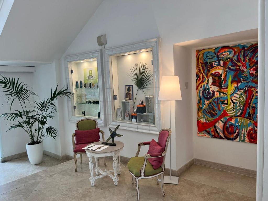 a living room with a table and chairs and a painting at Relais Corte Degli Aragonesi in Ischia