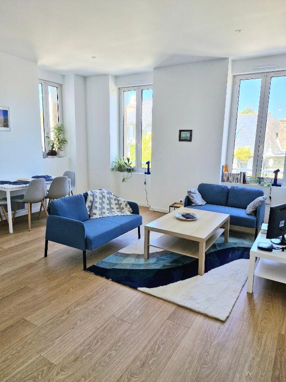 - un salon avec des canapés bleus et une table dans l&#39;établissement Grand appart renové centre ville, à Perros-Guirec