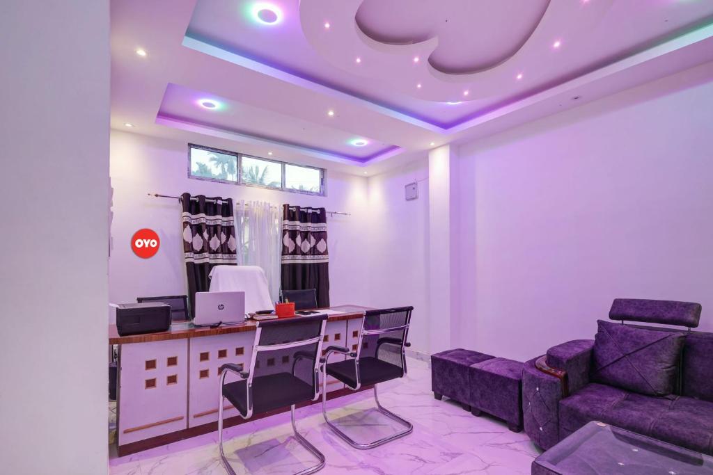 迪布魯加爾的住宿－Super OYO Flagship The Mahalaxmi Inn，客房设有书桌、沙发和桌子。