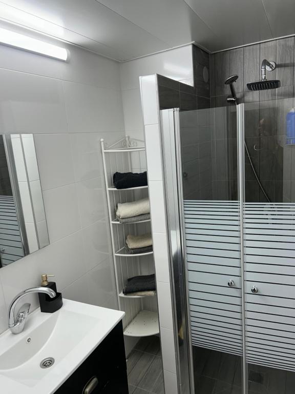 a white bathroom with a shower and a sink at Sima Suite in Ashdod