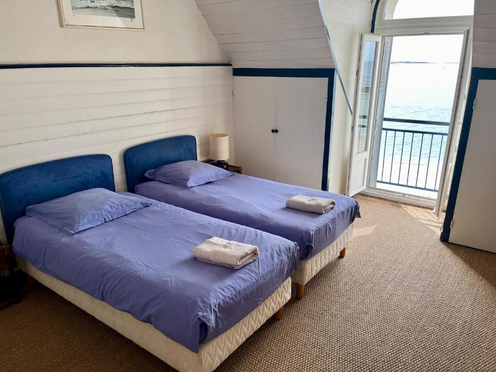 two beds in a room with a window at La Villa Ker Mat in Larmor-Plage