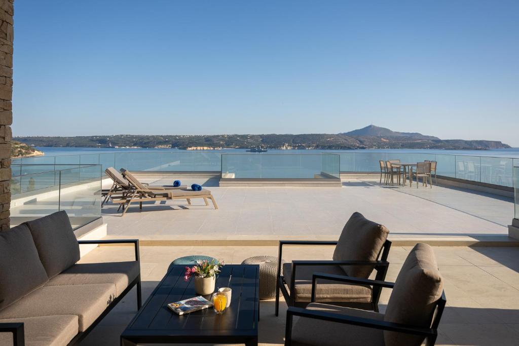 eine Terrasse mit Sofa, Stühlen und einem Tisch in der Unterkunft Seascape Kalyves in Kalyves