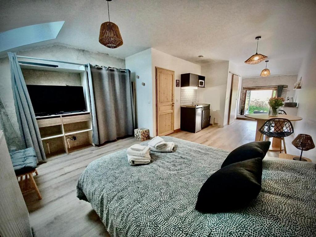 a bedroom with a large bed and a television at La Bergerie de Chantemille - Les Mésanges in Ahun