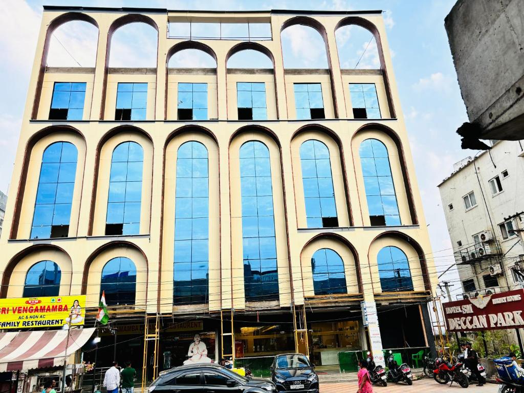 un grand bâtiment avec de nombreuses fenêtres donnant sur une rue de la ville dans l'établissement HOTEL SM DECCAN PARK, à Shamshabad