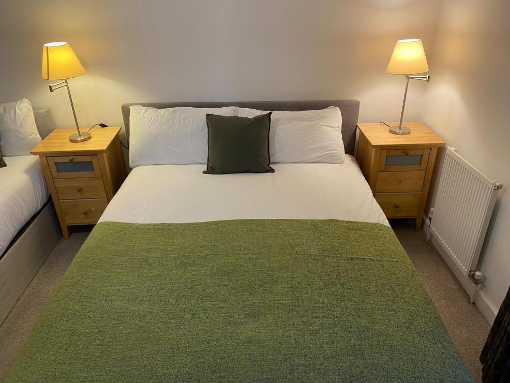 Camden Town Apartment في لندن: غرفة نوم بسرير كبير مع مواقف ليلتين