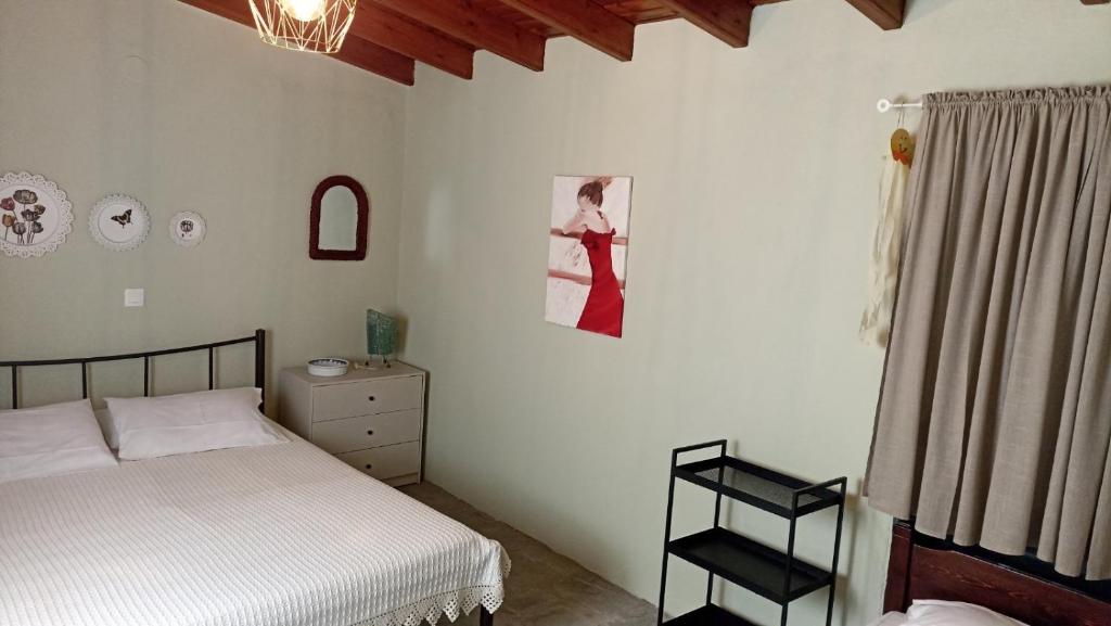 a bedroom with a bed and a picture of a woman on the wall at Anna’s Olive Grove in Ammouliani