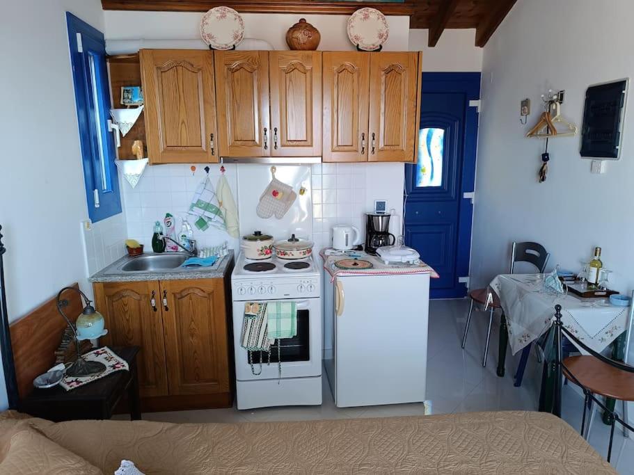 a small kitchen with a white stove and a sink at Kleopatra's apartment, Livadaki in Kámpos