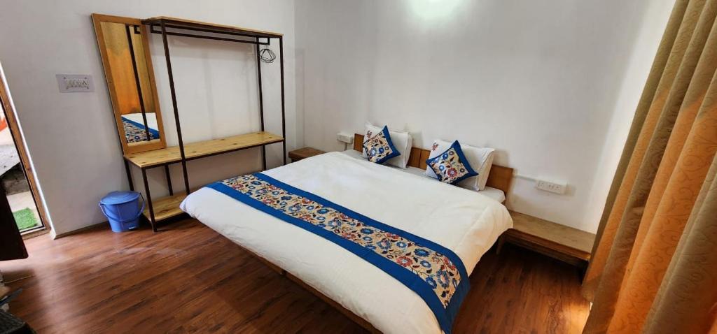 a small bedroom with a bed and a mirror at Seven Seas Guest House leh in Leh