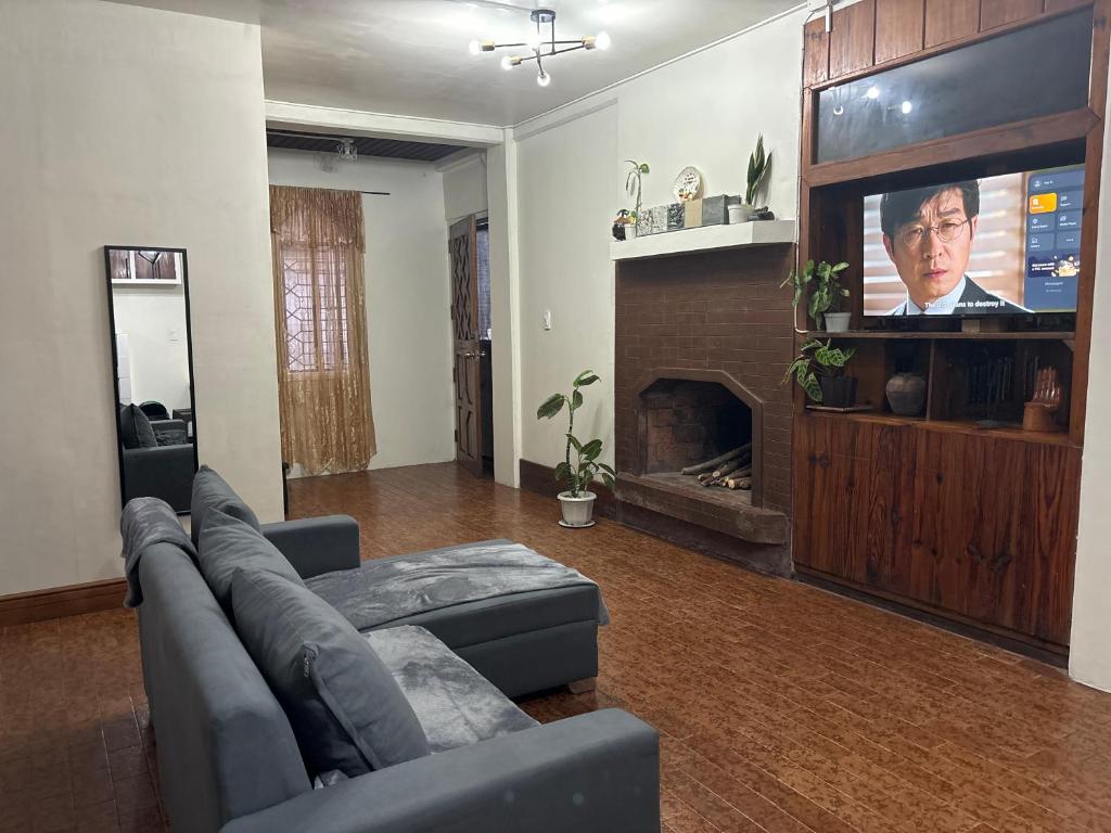 uma sala de estar com um sofá e uma televisão de ecrã plano em By the Old Swing em Baguio