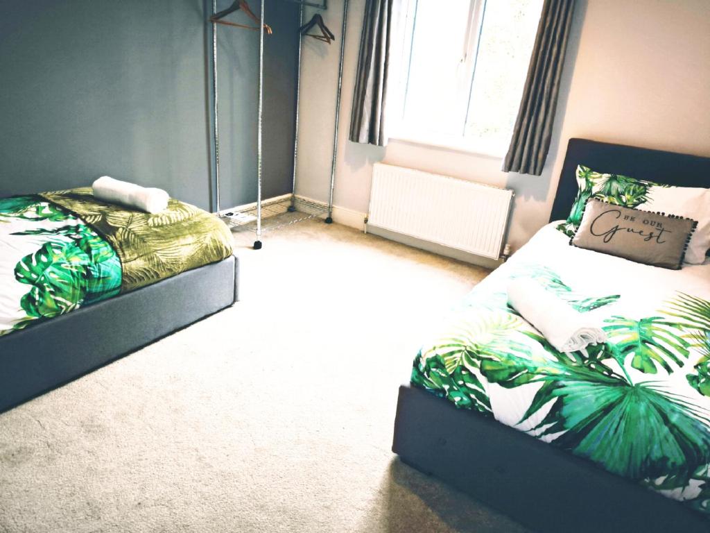 a bedroom with two beds and a window at Spacious 3 Bedroom Home for Families and Contractors with Wi-Fi, Parking, Sleeps 7 - Clark Property Estates in Southend-on-Sea