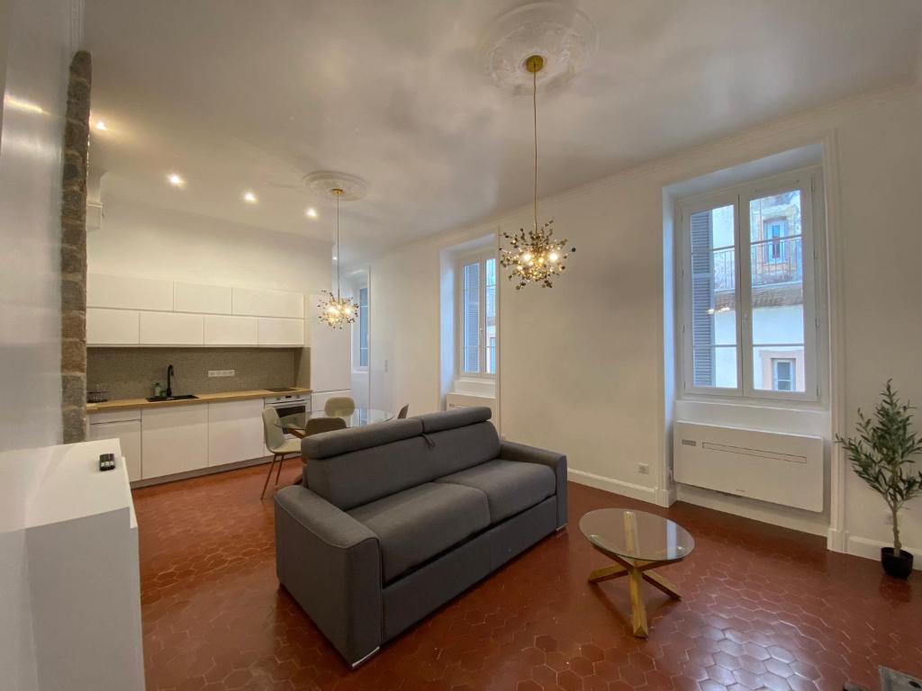 a living room with a couch and a kitchen at Grands T2 Cours Napoleon in Ajaccio