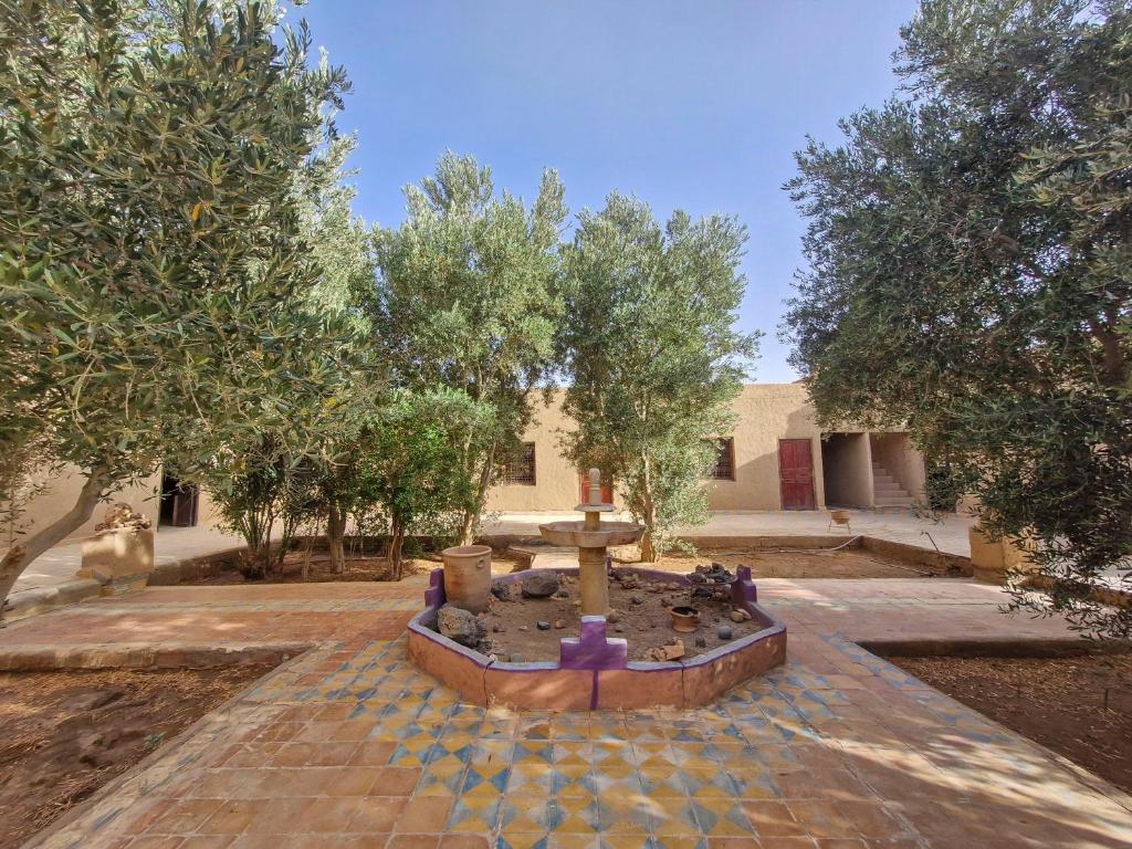 une fontaine au milieu d'une cour arborée dans l'établissement Riad Akour, à Merzouga
