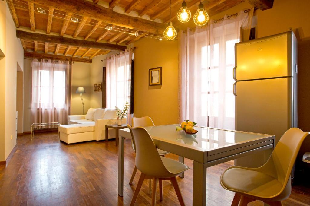 a kitchen and living room with a table and chairs at Casa del Sensale in Lucca