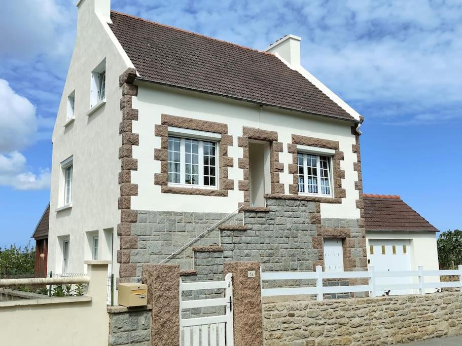 une maison avec une clôture blanche devant elle dans l'établissement Chez Dom et Pascal, à Plestin-les-Grèves