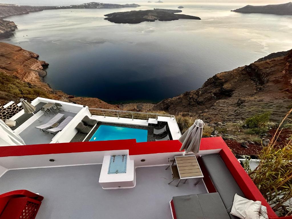 a house on the edge of a cliff with a swimming pool at Hara's houses in Imerovigli