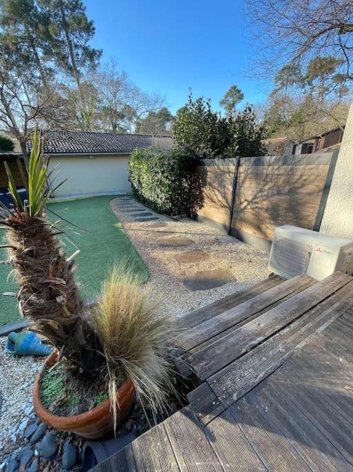 un jardin avec un banc en bois et quelques plantes dans l'établissement Maison Familiale- Bassin Arcachon - Au calme, à La Teste-de-Buch