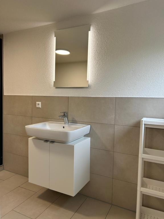 a bathroom with a white sink and a mirror at Ferienwohnungen in Heidenheim in Heidenheim
