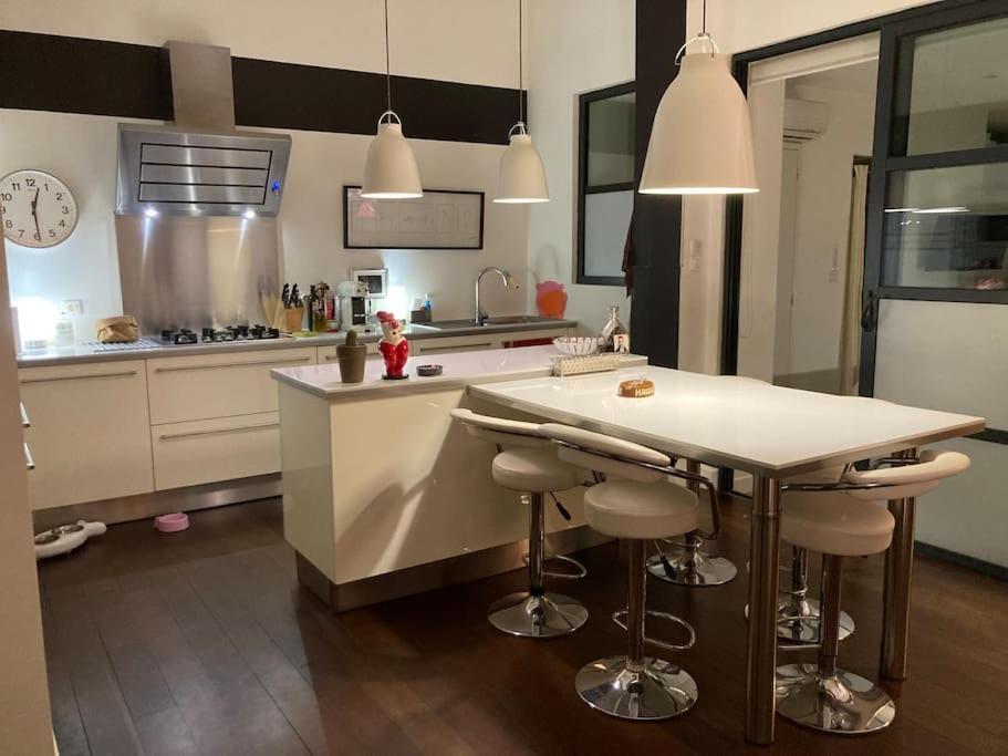 a kitchen with a counter and a island with bar stools at Maison standing avec jardin 10mn de Bordeaux in Talence