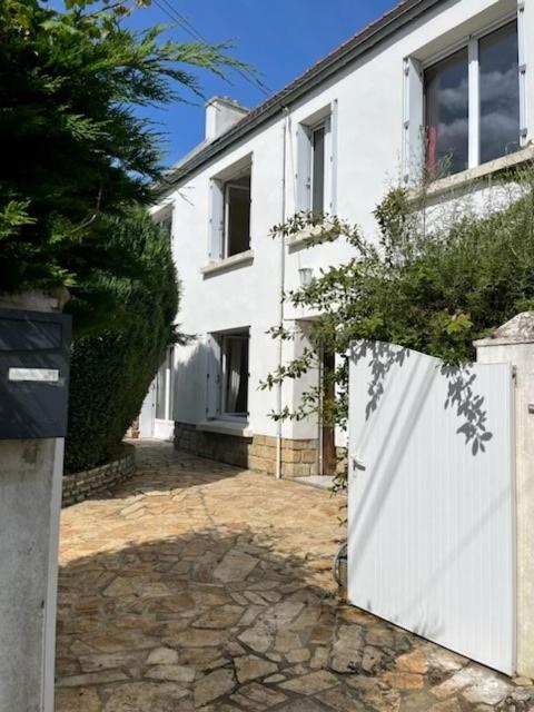 une maison blanche avec une clôture blanche et un bâtiment dans l'établissement Ty Mimi, à Plougastel-Daoulas