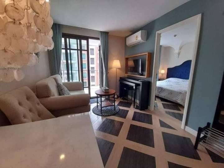 ein Wohnzimmer mit Sofa und ein Schlafzimmer in der Unterkunft Espana Condo Resort Pattaya in Jomtien Beach