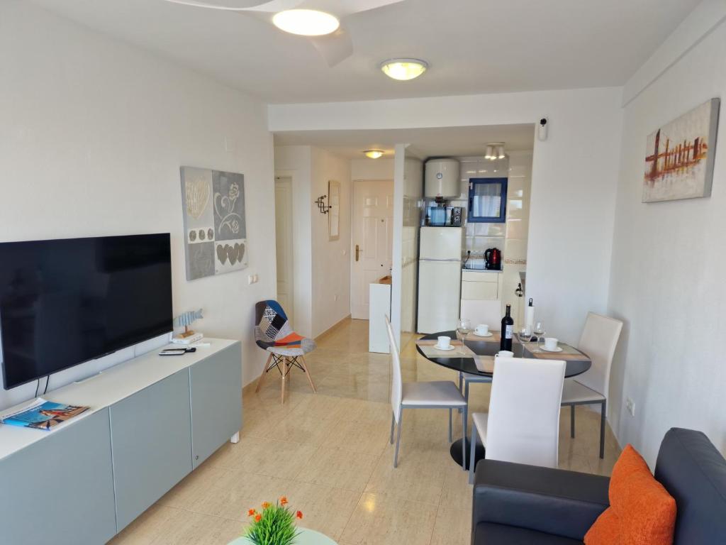 a living room with a television and a dining room at Apartment Bella Vista with sea view in Dehesa de Campoamor