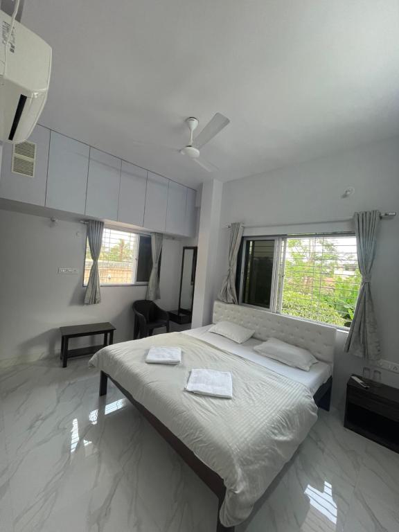 a bedroom with a bed with two towels on it at White Haven Homestay in Alibag