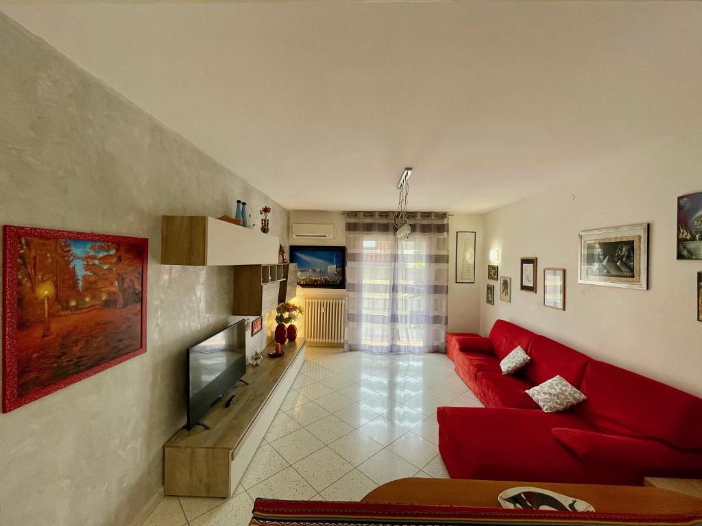 a living room with a red couch and a television at Venice Travel Dream Spacious Apartment near Venice in Mestre