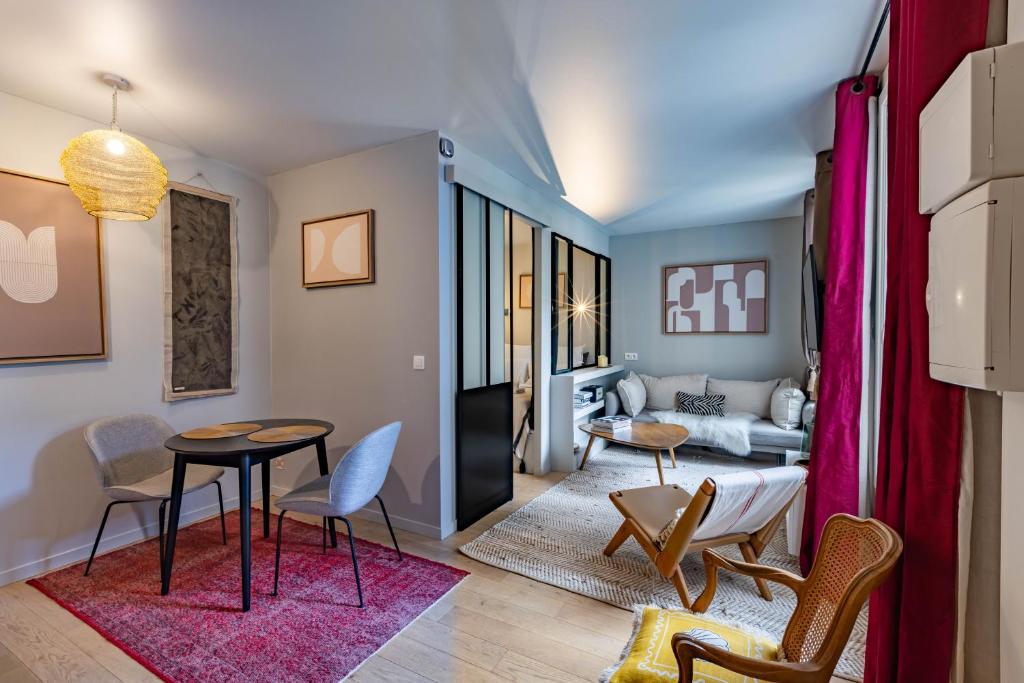 un salon avec une table et des chaises dans l'établissement Très bel appartement proche Tour Eiffel et Passy, à Paris