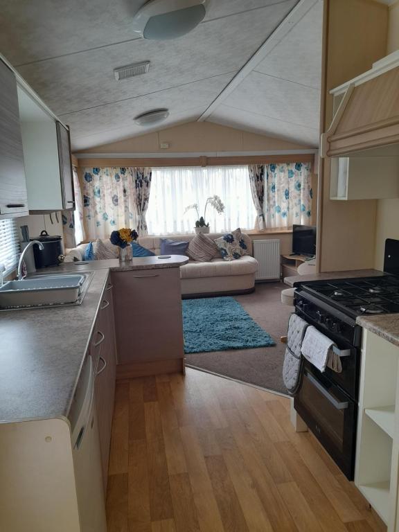 eine Küche und ein Wohnzimmer mit einem Sofa in der Unterkunft Blancos by the sea in Saint Osyth
